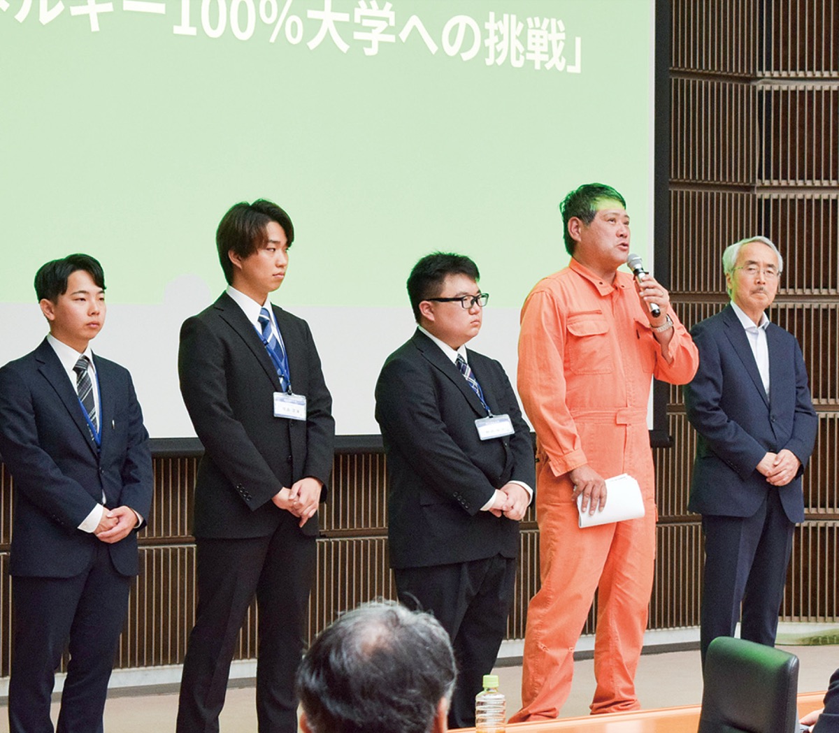 記念講演会であいさつする小山田代表（右から２人目）