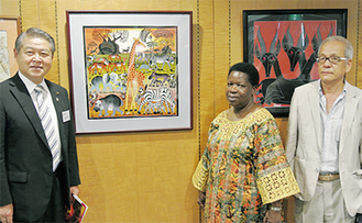 絵画の前に立つサロメ・タダウス・シジャオナ大使（中央）と加藤修平市長（左）、岩井事務局長（右）