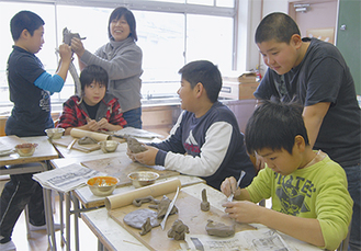 陶芸指導をする斎藤さん（左から３人目）