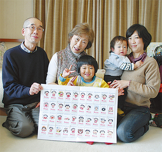 「集めたカードでみんなで楽しく遊びたいと思います」と越川さん家族＝18日・越川さんの自宅