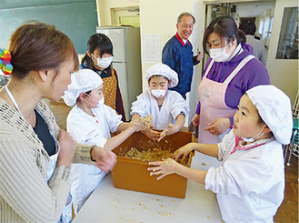 仲良く味噌を仕込む女子３人、左が湯川さん＝三保小学校家庭科室