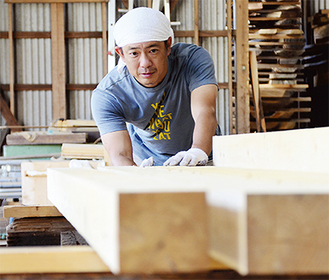 舞台に使用する木材を選ぶ小高さん＝南足柄市内山の工房