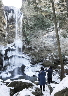 凍結した滝を眺める観光客　＝夕日の滝・1月26日