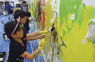 壁に絵を描く参加者