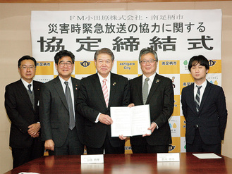 協定書を持つ加藤市長（左から３人目）、鈴木社長（同４人目）