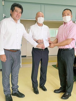寄付金を手渡す井上社長（中央）と小山田さん（左）