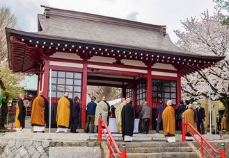 落慶式で仁王門をくぐる僧侶ら