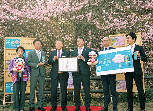満開の桜のもと微笑む関係者