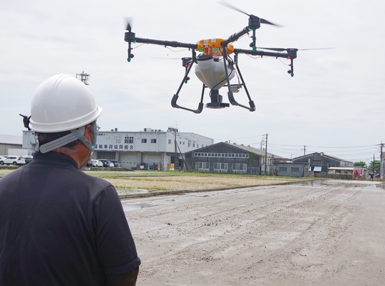 ドローンによる種まきの様子。約２千平方メートルの土地での直播作業はスタッフ２人が数分間で終了させた