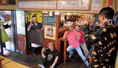 浅田カメラマンの指示の中、撮影に臨む＝6月17日、居酒屋かっぱ