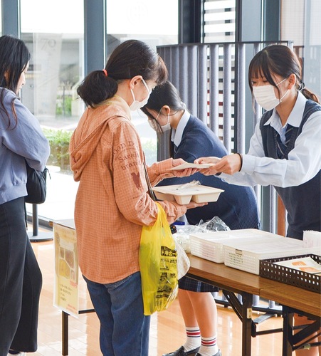 町民に弁当を手渡す吉田島高校の生徒