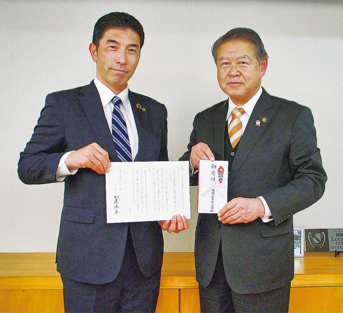 寄付金を手渡した中村社長（左）
