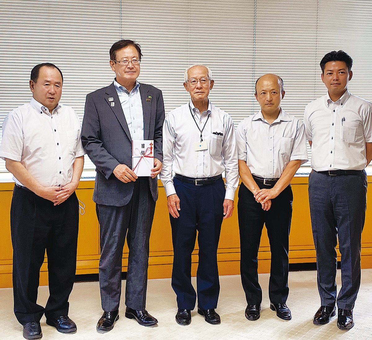 寄付を受けとる湯川裕司町長（左から２人目）