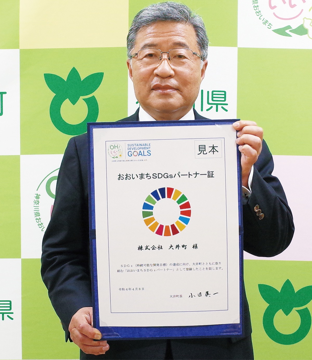 パートナー証の見本を持つ小田町長