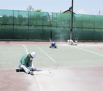 ひび割れが発生した市立おおね公園内テニスコートの修復工事