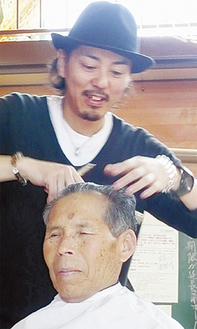 お年寄りの髪の毛をカットする吉田さん
