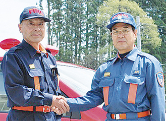 上野哲男秦野市消防団長（右）は、気仙沼市の武山文英消防団長と握手を交わした