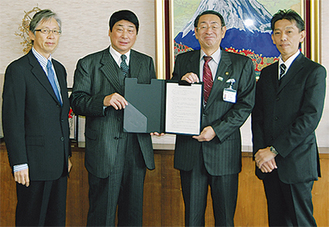 協定書を手にする鈴木代表取締役（中央左）