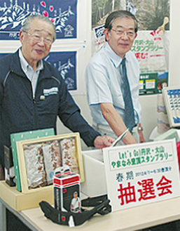 抽選する松下会長（左）と松田会長