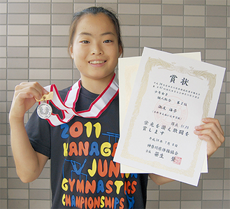 賞状とメダルを掲げる瀬尾さん