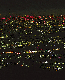 右手奥には東京タワーの姿、左奥の夜空に浮かぶ白い点々はスカイツリー。手前の影は大山に続く稜線　＝撮影・八木茂さん＝