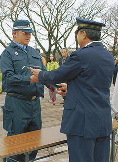 齋藤署長からピッケルを受け取る高楯隊長（左）