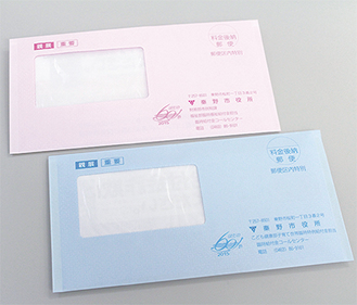 送付される臨時福祉給付金（ピンク色）と子育て世帯臨時特例給付金（水色）の封筒