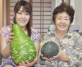 母・清子さんと共に収穫した果実を手にする桑原さん（左）