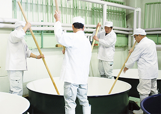 発酵の均一化のため撹拌を行う蔵人たち