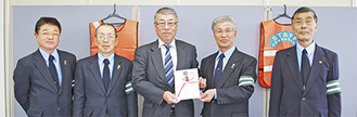 ベストを寄贈した佐藤社長（中央）と中田会長（右から２番目）