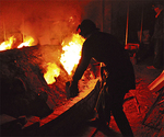 穴窯の側面にある穴から薪をくべ、炎に勢いをつける