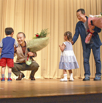 舞台挨拶で子どもから花束を受け取る大地さん（左）と山田監督
