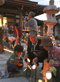 竹灯籠に火を灯す家族