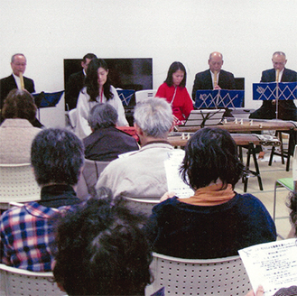石巻市内の集会所で被災者を前に演奏を披露する真里子さん（中央左）と紗佑里さん（同右）