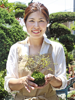制作した苔玉を手に、笑顔を見せる幸加木さん