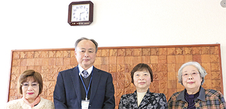 寄贈した時計の下に立つ北婦人会の神戸会長（右から２番目）らと杉崎校長