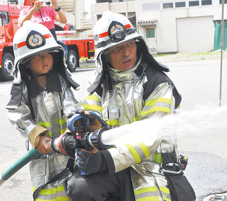 消防服を着て放水を行う園児