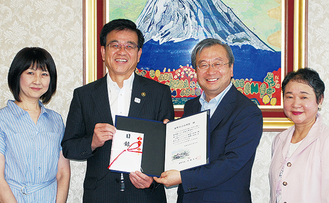 加藤理事長（中央右）が高橋市長に寄付を手渡した