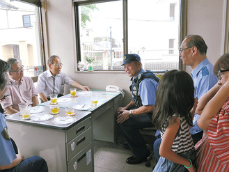 友の会の内藤会長（中央左）と話す姫野警察官とその家族