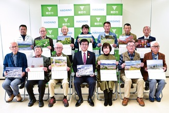 担当月のページを持つ写真採用者13人と高橋市長（前列中央）