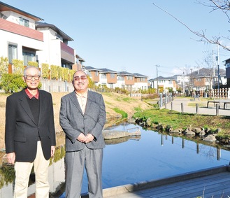 今泉あらい湧水公園と街並みをバックに立つ石塚会長(右)と三杉さん(左)