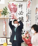 当選を祝し、花束を掲げる高橋氏