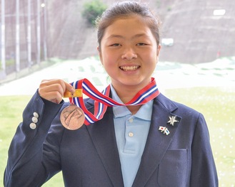 メダルを手に笑顔の田村さん