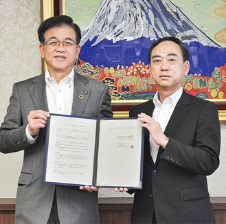 協定書を手にする高橋市長（左）と浅田執行役員