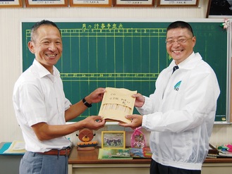 久下支部長（右）から平井校長に鉛筆が贈られた