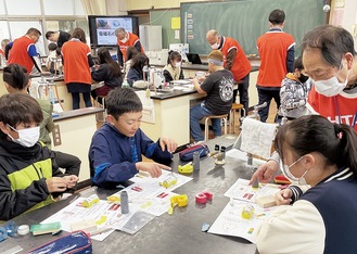 ハイエンス神奈川メンバーのアドバイスを受けながら難易度の高いクリップモーターを作る児童