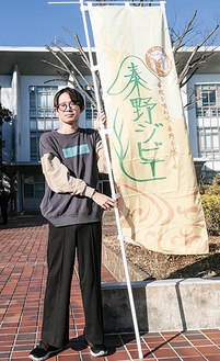 坂口さんとデザインが印刷されたのぼり旗
