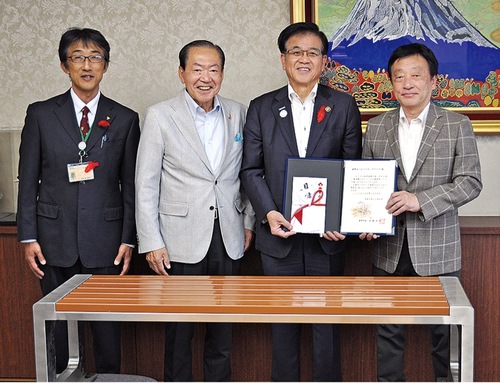 目録を手渡す尾谷会長（右端）