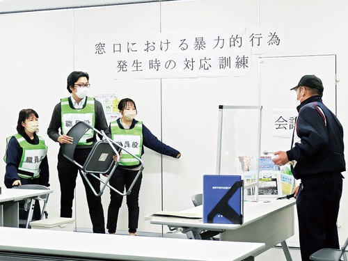 激高し刃物などを持ち出した市民役から距離を取る職員ら