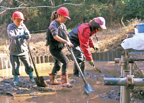 泥だらけになりながら一生懸命かき出す児童